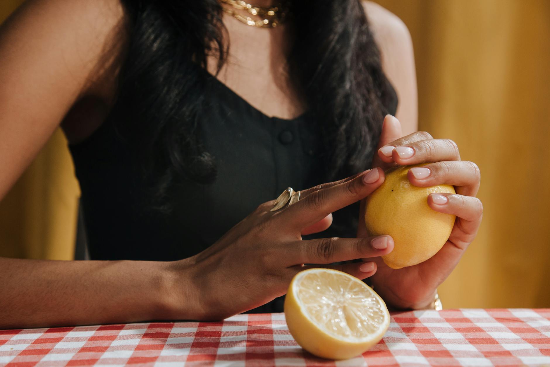 Close-up of hands holding a fresh lemon, symbolizing slowness and intention
