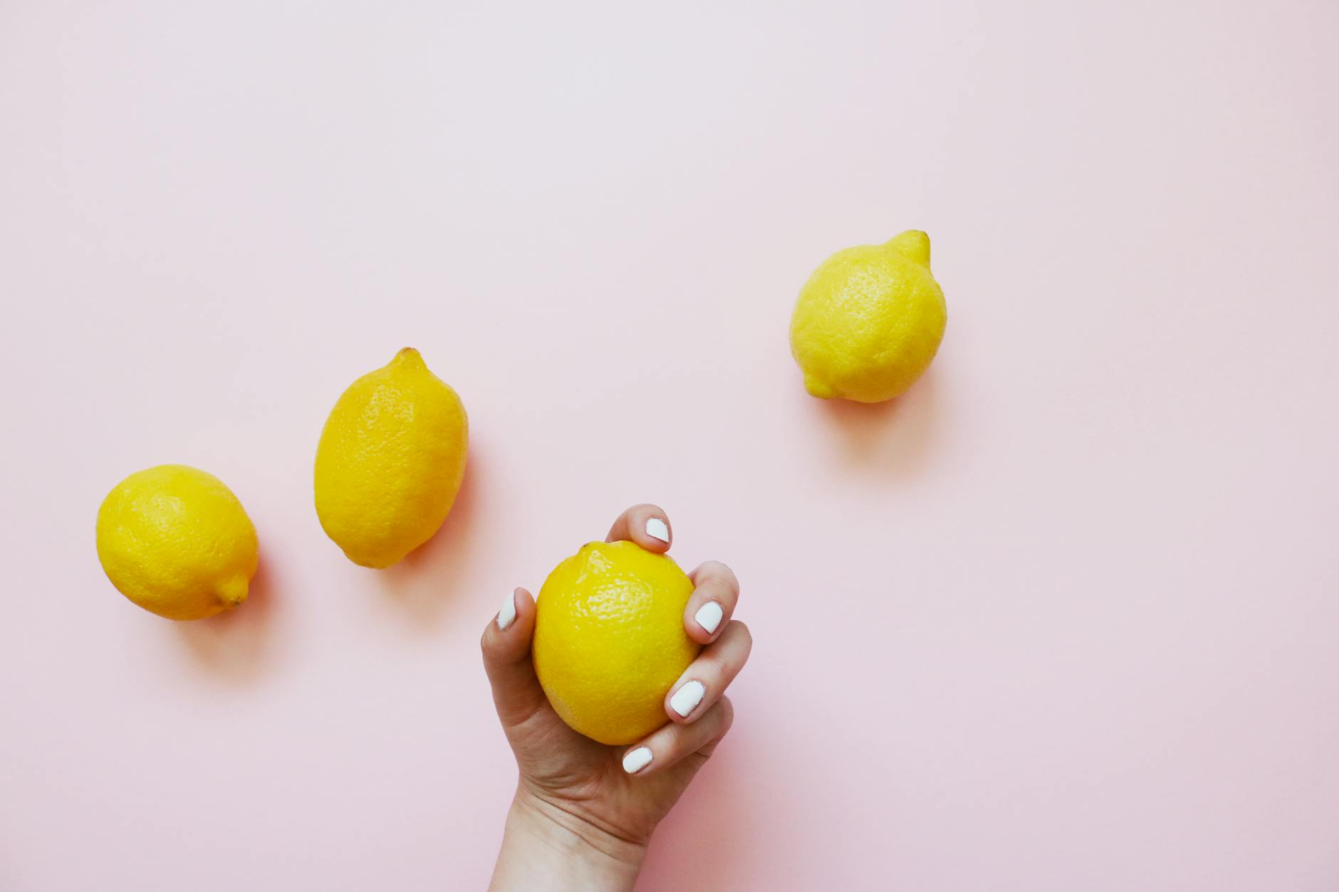 Close-up of two fresh lemons held in cupped hands, symbolizing shared connection and intimate exploration