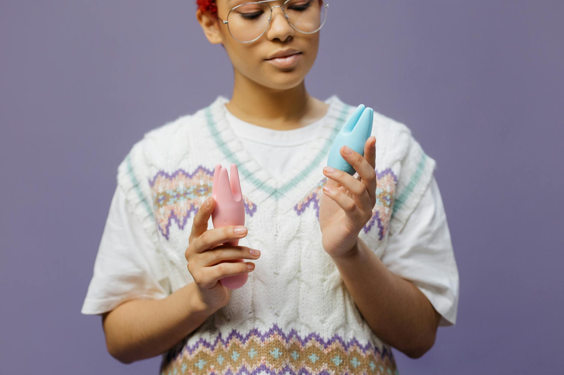 Woman holding vibrators in a reflective moment of self-discovery