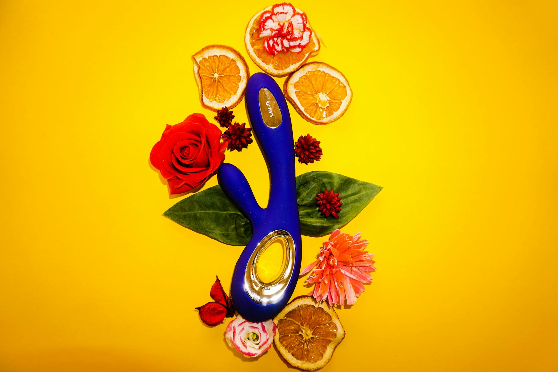 Close-up of hands holding a sleek lemon clitoral vibrator against a soft background