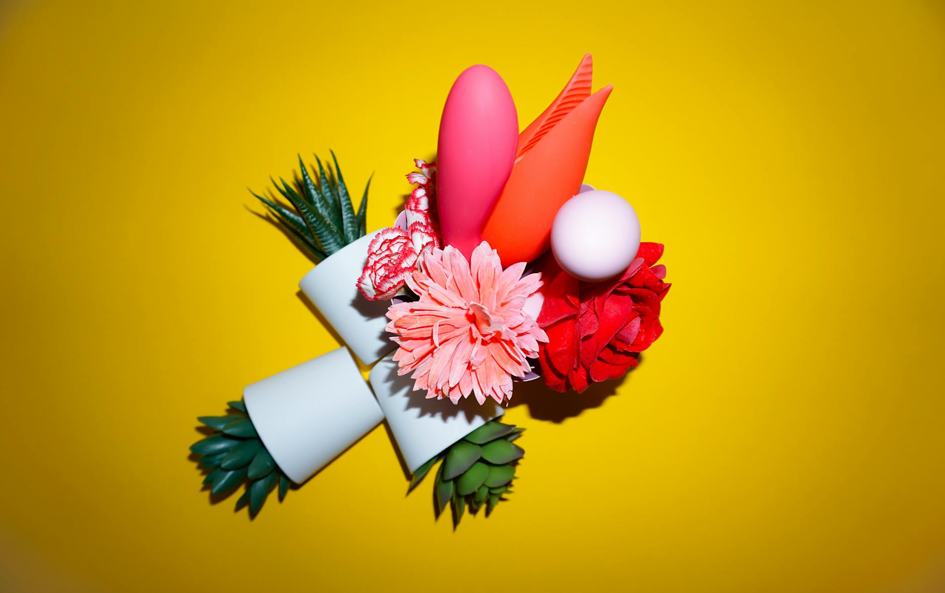 Vibrant arrangement of abstract objects and flowers on bright yellow background, symbolizing hope and renewal